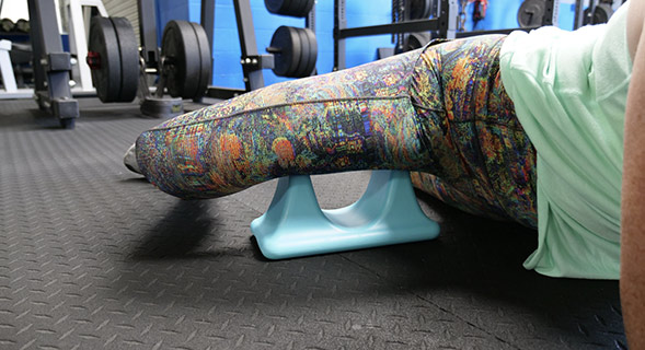 A woman demonstrating the Psoas Quick Release Self-Massage Tool